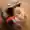 A dog sits in an open leather suitcase between clothes and looks out.