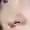 Close-up of a woman's nose. She has blue eyes, red lips and freckles.
