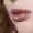 Close-up of a woman's mouth. She has red curly hair and red lips.